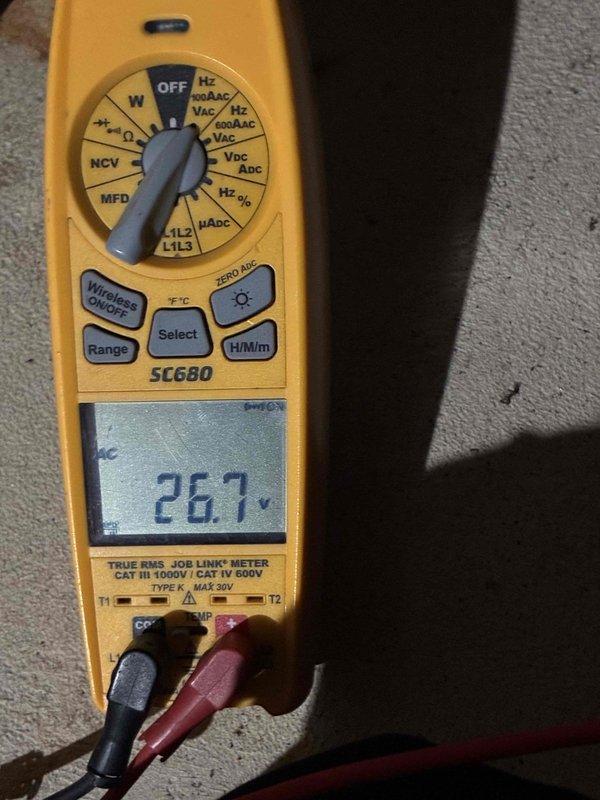 Performed standard tune-up on HVAC system. Conducted electrical testing using Fieldpiece SC680 multimeter, confirming voltage reading of 26.7V. Removed access panel to inspect interior components, noting rust accumulation and wear on panel surfaces. Reconnected and secured all wiring connections (green, white, red, and black).