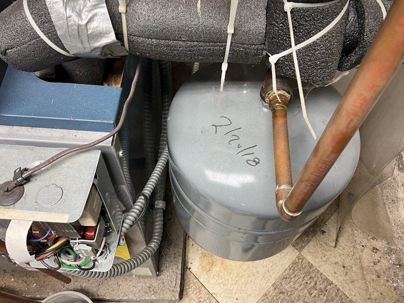 Assessed and replaced aging HVAC system components in utility area, including installation of new condensate pump with properly insulated copper lines and electrical connections. System replacement included proper mounting of water heater tank with appropriate galvanized steel piping and fittings against concrete block wall.