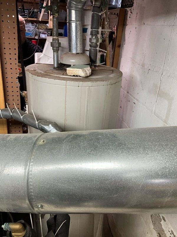 Assessed and replaced aging HVAC system components in utility area, including installation of new condensate pump with properly insulated copper lines and electrical connections. System replacement included proper mounting of water heater tank with appropriate galvanized steel piping and fittings against concrete block wall.