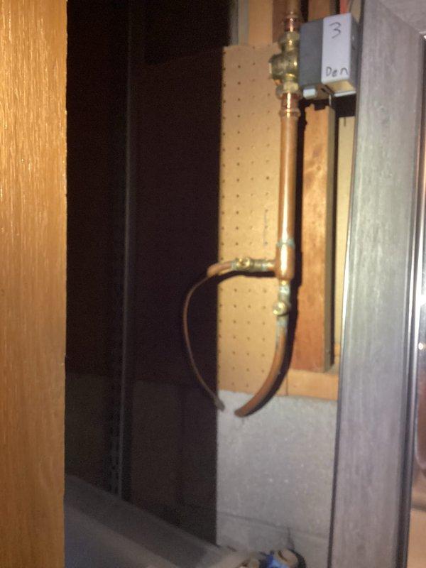 Performed inspection and documentation of plumbing infrastructure in unfinished basement utility area. Examined copper piping system including valve connections and control components. Verified proper installation of water heater/tank and noted all visible plumbing runs through ceiling joists (copper and PVC) were in serviceable condition.