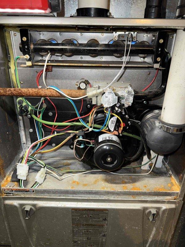Performed routine commercial tune-up on HVAC system. Noted significant mineral buildup and corrosion around valve connections on heat exchanger pipes. Cleaned accessible components and inspected electrical connections, observing proper wire terminations at motor assembly. System operational but recommend follow-up service to address progressive corrosion issues on heat exchange components.