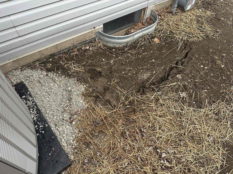 Completed foundation inspection and cleanup around newly installed HVAC unit. Removed debris from drainage channel and reapplied erosion control straw around foundation perimeter and condensate drainage area. Verified proper installation of drain pan and checked gas meter connections.