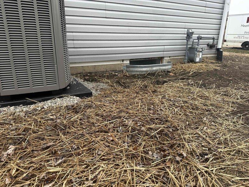 Completed foundation inspection and cleanup around newly installed HVAC unit. Removed debris from drainage channel and reapplied erosion control straw around foundation perimeter and condensate drainage area. Verified proper installation of drain pan and checked gas meter connections.