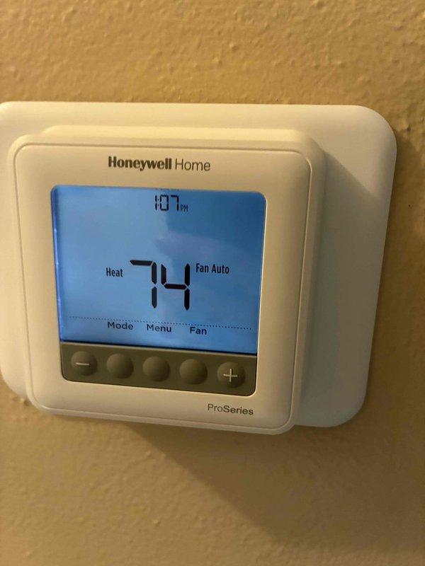 Performed routine HVAC tune-up which included inspection of the Honeywell ProSeries thermostat (confirmed proper operation with heat set at 74°F and fan in auto mode). Examined and documented condition of ductwork, noting minor surface wear and scratches on the metal surfaces with some dust accumulation in the upper sections.