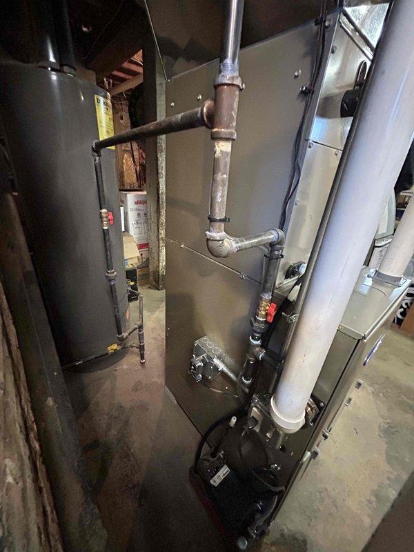 Completed installation of a complete HVAC system including a new Honeywell ProSeries programmable thermostat and furnace unit with proper ductwork connections. System features PVC exhaust venting and copper line connections, with all components tested and functioning correctly at 54 degrees.