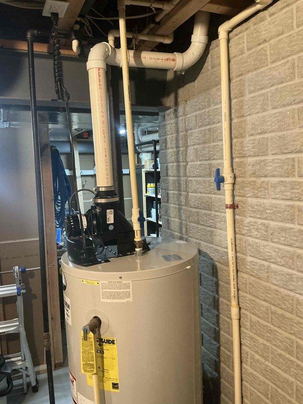 Conducted water heater assessment in basement utility room. Existing unit shows signs of age with potential efficiency concerns. Recommend replacement with newer model that includes updated PVC ventilation system and improved pump assembly to ensure better performance and reliability.