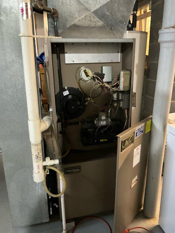 Performed inspection of an Armstrong furnace system in basement utility area, documenting condition of internal components including blower motor, wiring, and control systems. Examined the filter system (16 x 25 x 1 Filtrete) and evaluated the PVC condensate drainage configuration. Assessment focused on determining replacement requirements for the aging unit.