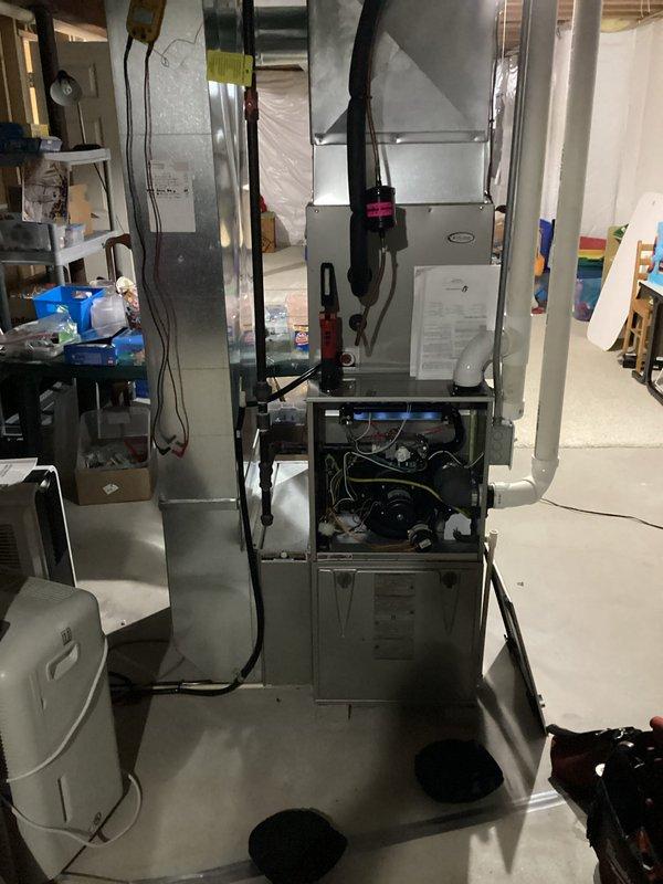 Completed comprehensive tune-up of basement HVAC system including inspection of furnace internal components (motor, wiring, mechanical parts) and associated ductwork. Examined condensate line with pink/magenta valve and verified proper connection to main plumbing system. Inspected ceiling infrastructure including proper mounting of PVC pipes and metal ducts to ensure system integrity and optimal performance.