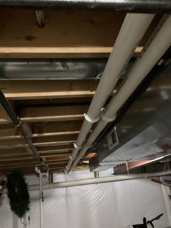 Completed comprehensive tune-up of basement HVAC system including inspection of furnace internal components (motor, wiring, mechanical parts) and associated ductwork. Examined condensate line with pink/magenta valve and verified proper connection to main plumbing system. Inspected ceiling infrastructure including proper mounting of PVC pipes and metal ducts to ensure system integrity and optimal performance.