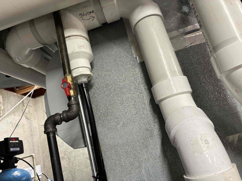Performed diagnostic pressure testing on the furnace system using manometer, obtaining baseline reading of 0.0. Inspected drainage assembly including PVC pipe connections and shutoff valve functionality. Confirmed proper operation of water management components related to furnace operation.