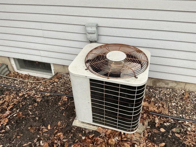 Completed comprehensive assessment for HVAC system replacement, including inspection of aging outdoor air conditioning condenser showing significant weathering and the existing indoor furnace unit installed against basement wall. Documented current system condition with photos, noting ventilation, electrical connections, and mounting configurations to prepare detailed replacement proposal.