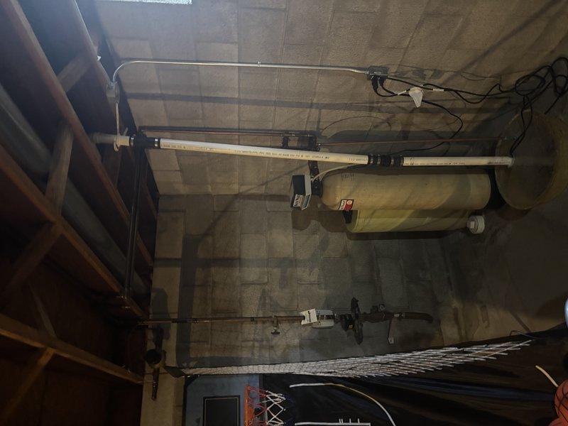 Conducted site assessment of water heater installation in utility room. Inspected existing plumbing infrastructure, including PVC/copper pipe runs along ceiling and wall framing. Evaluated water tank condition, connecting fixtures, and supporting brackets. All systems appear properly installed with appropriate insulation and safety labeling in place.