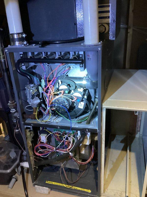 Performed routine maintenance on HVAC system, inspecting electrical components and connections. Noted water damage in corner of room affecting baseboard and drywall. Verified proper wiring connections within furnace unit and confirmed all systems functioning correctly after tune-up.