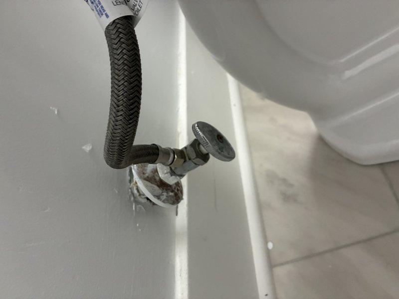 Conducted pre-paid plumbing maintenance visit to inspect wall-mounted supply line connection and exposed copper piping. Observed deteriorated drywall around supply line entry point with possible mineral buildup. Examined damaged wall section revealing copper pipe with two visible joints (coupling and elbow) showing signs of aging and potential corrosion. Documented condition of plumbing infrastructure for future reference.