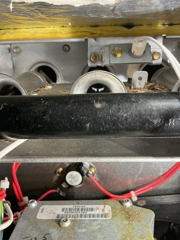 Performed routine maintenance on gas furnace unit, opening access panels to inspect blower motor assembly and electrical components. Cleaned accumulated dust and debris from interior components including control board and gas valve assembly. Checked all wiring connections (red, yellow, green, white, blue) to ensure proper functionality and secure attachment.