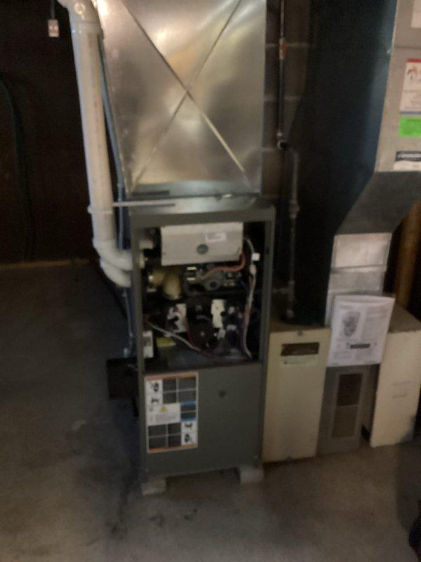 Performed routine maintenance tune-up on residential HVAC furnace system. Inspected internal components including wiring, valves, and mechanical parts with front panel removed. Checked PVC venting and connected ductwork for proper operation and airflow.