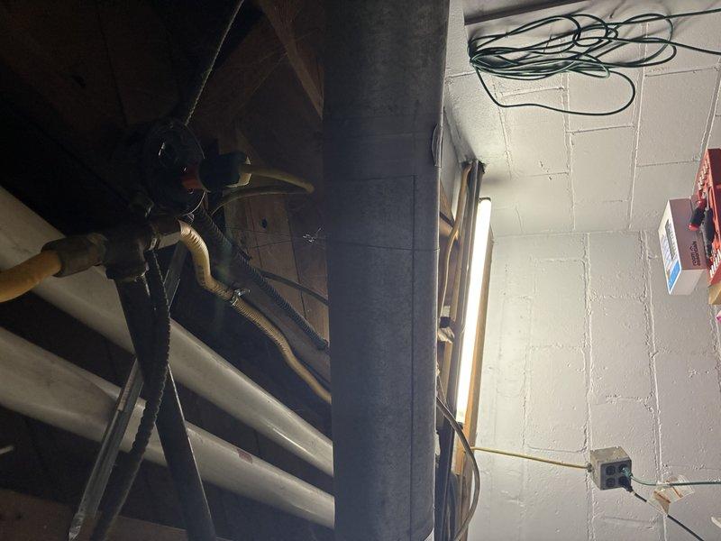 Conducted comprehensive plumbing inspection of basement utility area, examining primary pipe infrastructure and connections. Identified aging copper piping with visible corrosion and tarnishing at PVC transition points, particularly at L-shaped junction where dissimilar materials meet. Documented potential areas of concern for future maintenance consideration.