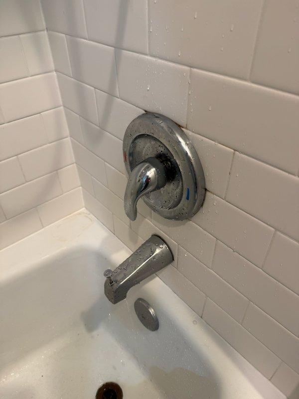 Successfully installed a chrome shower/tub combination fixture including a lever-handle temperature control and matching bathtub spout on white subway-tiled wall. Tested operation and confirmed proper water flow and temperature regulation with no leaks present at connection points.