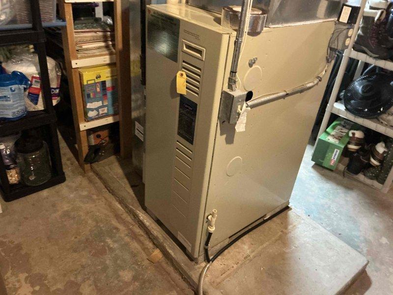 Performed visual assessment of existing HVAC system in basement utility area. Current unit is an aging beige/tan furnace with standard vertical design and connected ductwork. System evaluation indicates replacement is recommended with appropriately sized equipment to ensure optimal performance and efficiency for the home.