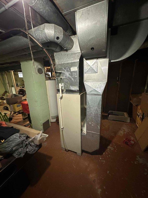 Conducted comprehensive assessment of existing HVAC system in basement utility room. Documented aging furnace/air handler unit with connected galvanized metal ductwork system. Evaluation confirmed need for full system replacement due to equipment condition and potential efficiency improvements.