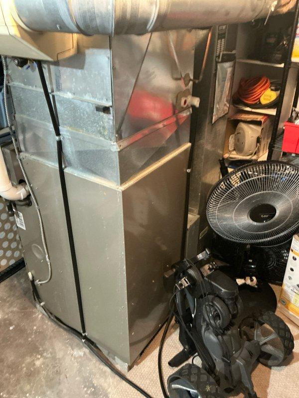 Conducted assessment of aging HVAC system in utility room, examining furnace unit with compromised connections and deteriorating ductwork. Recommended full system replacement with new high-efficiency furnace, properly sized ductwork, and upgraded humidifier to replace existing unit. Documented current installation issues including improper ventilation and potential condensate drainage problems.