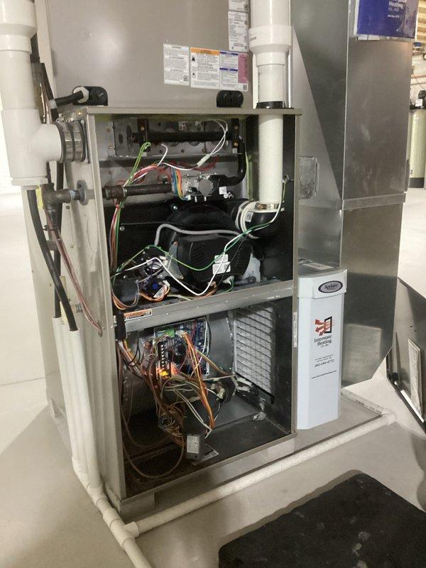 Performed routine maintenance tune-up on residential furnace system. Inspected internal components including control board, wiring connections, and PVC ventilation pipes. Identified and cleaned minor rust/water damage near condensate drain line, securing loose drain hose with new clamp to prevent future leakage issues.