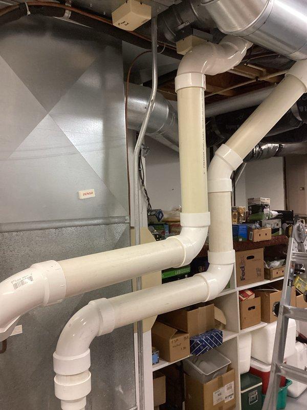 Performed routine HVAC system tune-up including inspection of existing ductwork and ventilation components. Checked PVC drainage pipes for proper installation and functionality. Examined furnace unit for operational efficiency and inspected nearby plumbing components, noting some rust/corrosion on metal surfaces that should be monitored but does not currently affect system performance.