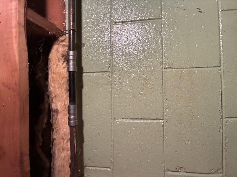 Diagnosed and repaired water leakage issue in residential plumbing system. Removed wall section to access affected pipes, identified failed coupling joints on vertical supply line, and replaced damaged fittings. Inspected surrounding basement piping system for additional moisture issues and verified proper system operation after repair.