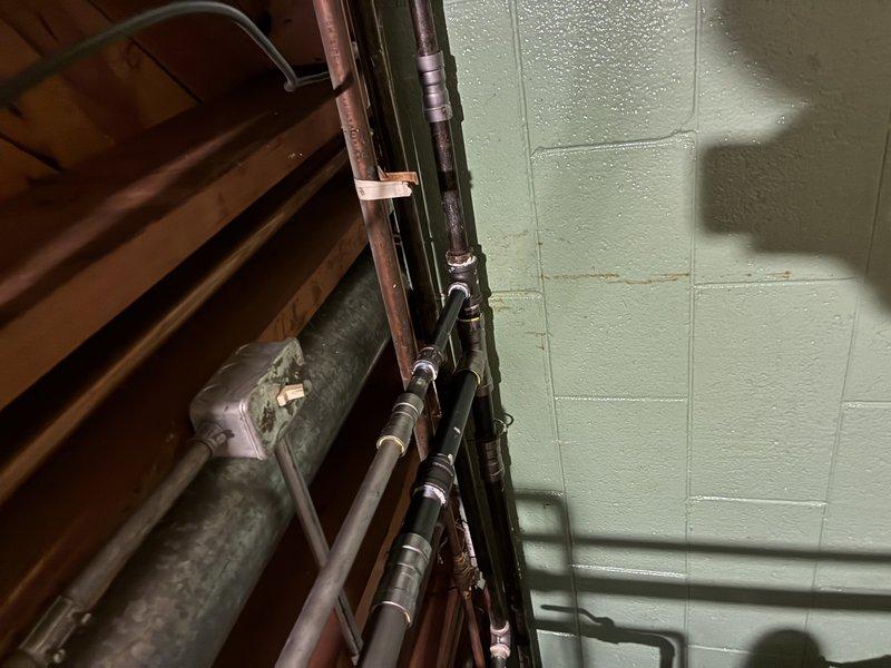 Diagnosed and repaired water leakage issue in residential plumbing system. Removed wall section to access affected pipes, identified failed coupling joints on vertical supply line, and replaced damaged fittings. Inspected surrounding basement piping system for additional moisture issues and verified proper system operation after repair.