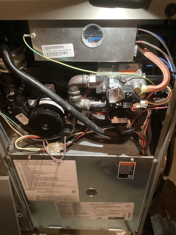 Performed standard tune-up service on residential furnace system. Inspected interior components including gas valve assembly, control module, and electrical connections - all found in normal working condition with no visible damage or abnormal wear. Examined condensate drainage system with PVC piping; verified proper installation and functionality of all ventilation components.