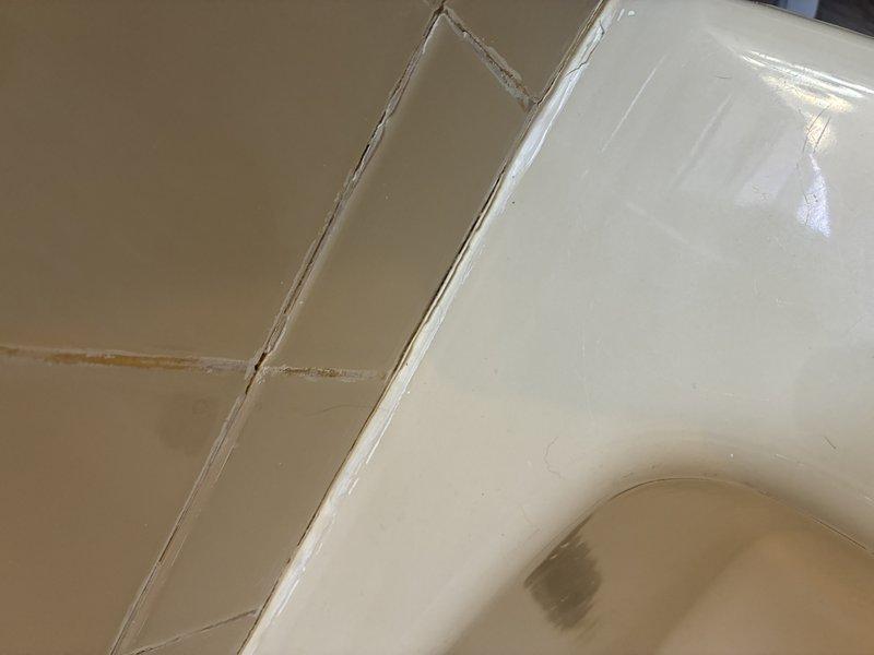 Completed installation of new shower/tub unit with proper sealing and caulking at all wall junctions. Applied waterproof sealant along fixture-to-wall seams to prevent water intrusion. Tested installation for proper drainage and water-tightness with all surfaces demonstrating appropriate water beading and no leakage at tile-to-fixture transitions.