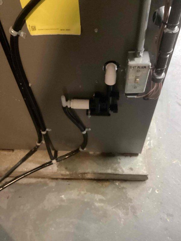 Installed new condensate drain assembly on 1st floor air handler unit. Secured existing refrigerant lines with zip ties to improve organization and prevent vibration damage. System is now properly draining with no leaks observed during final inspection.