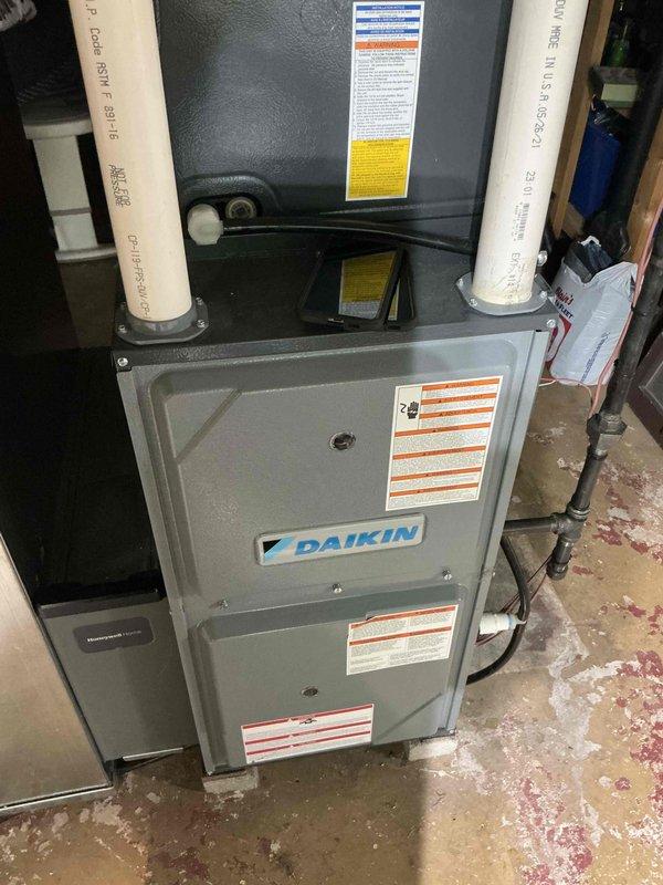 Performed routine tune-up on Daikin furnace system. Inspected unit for proper operation and ventilation, noting adequate PVC intake and exhaust connections. Conducted temperature diagnostics with readings at 103.2°F, confirming system is operating within normal parameters. Checked condensate drainage system for proper function and noted minor mineral buildup at joints that does not currently impact performance.