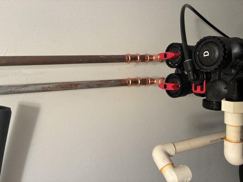 Completed water heater installation of Capri unit with proper copper piping connections. Installed control valve assembly with marked flow settings and connected to existing PVC drainage system. All components were secured to wall with no leaks observed during final inspection.