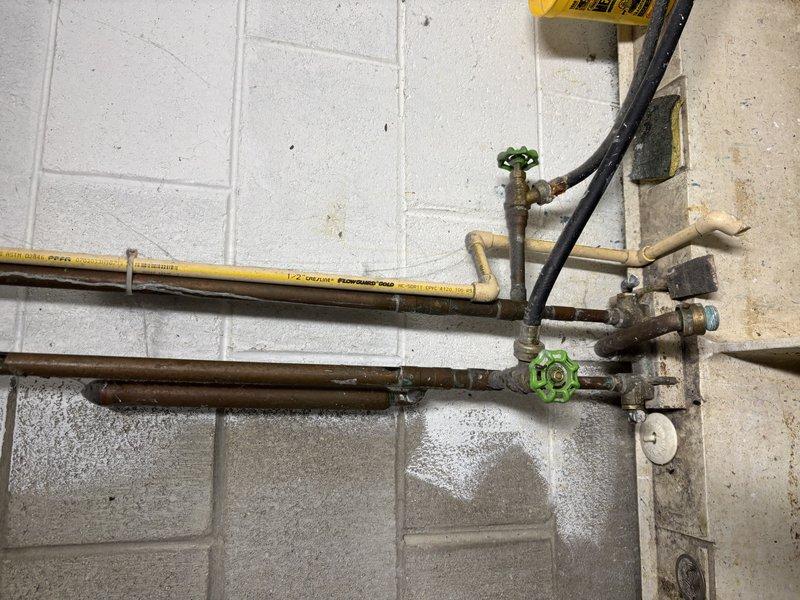 Conducted inspection of customer's water heater system and associated plumbing infrastructure. Examined copper piping connections, vent pipe installation, and operational status of control valves. Noted minor evidence of previous water leakage near valve connections, but confirmed system is currently functioning properly with no active leaks or safety concerns.