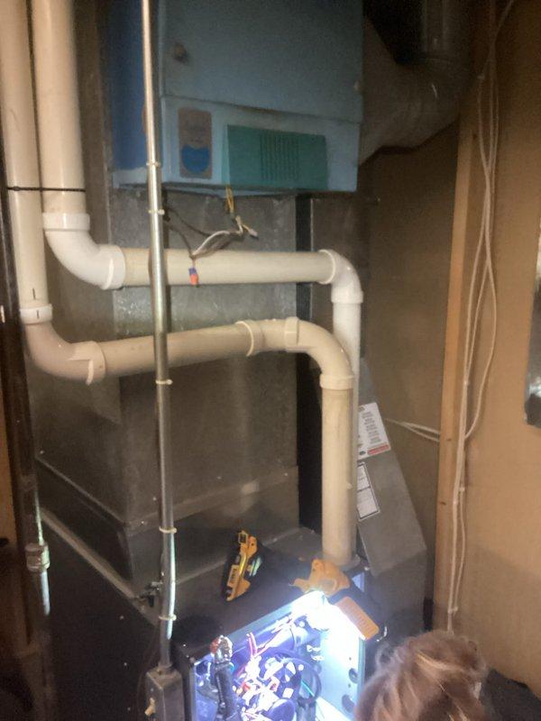 Responded to a no-heat call for an aging HVAC system (10+ years). Upon inspection, accessed the furnace control panel to diagnose electrical components and wiring connections. Performed comprehensive system evaluation, focusing on critical components visible in the utility area installation with connected PVC ventilation piping and ductwork.