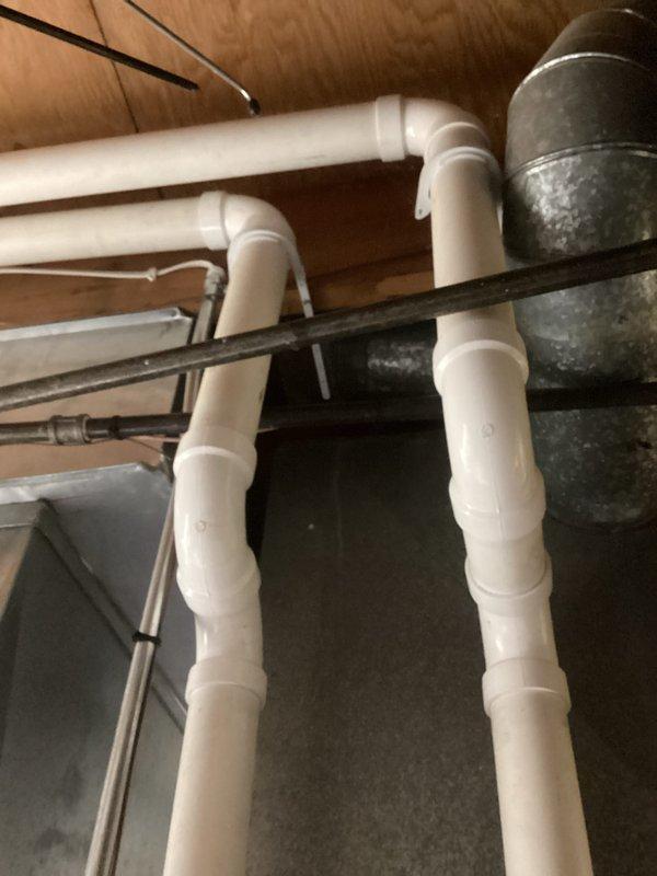 Performed routine HVAC tune-up service, which included inspection of the plumbing infrastructure and ventilation ducts in the utility area. Verified system leveling using calibration tools and checked electrical connections where multiple colored wires were present to ensure proper functionality.