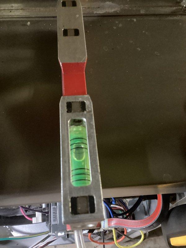 Performed routine HVAC tune-up service, which included inspection of the plumbing infrastructure and ventilation ducts in the utility area. Verified system leveling using calibration tools and checked electrical connections where multiple colored wires were present to ensure proper functionality.