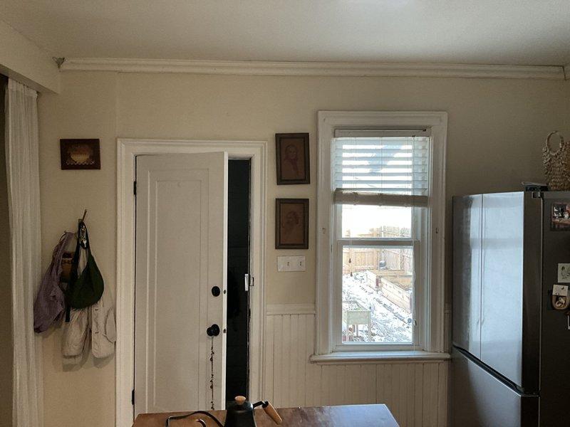 Conducted site assessment for mini-split installation, evaluating interior wall space adjacent to exterior door for potential indoor unit placement. Examined exterior area through window to determine optimal condenser location and assess available space for line set routing. Property layout appears suitable for standard mini-split configuration with minimal modifications required.