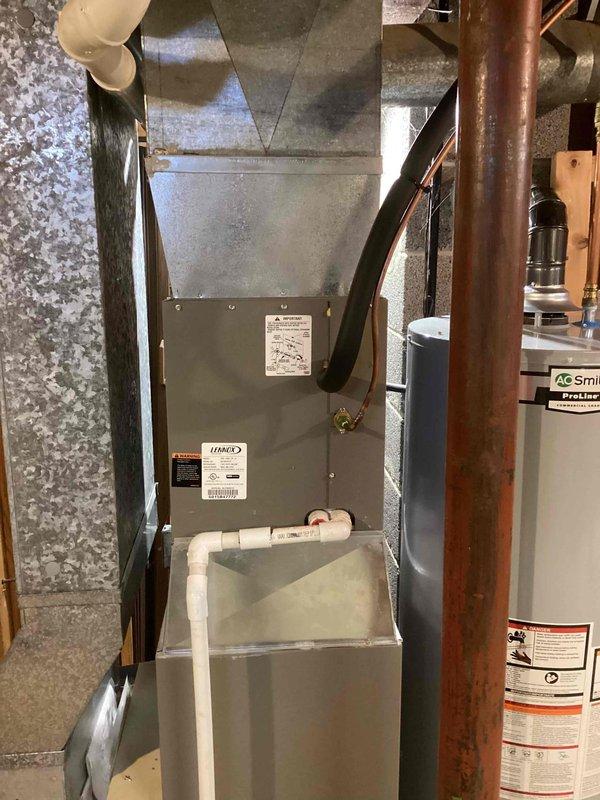 Performed routine tune-up on residential HVAC system located in basement utility area. Inspected furnace unit with front panel removed to examine internal components including wiring, motors, and control boards; all systems functioning properly. Verified proper operation of condensate drainage system and confirmed no leaks or damage to connected ductwork and piping.