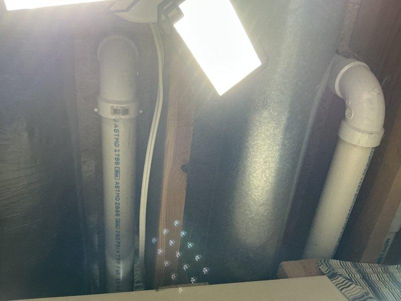 Completed inspection of existing HVAC system installation in utility space. Documented primary furnace/air handler unit with associated PVC exhaust/intake piping, copper refrigerant lines, and connected ductwork. System appears to have standard installation with proper venting configuration. Photos taken of plumbing connections and main HVAC unit for reference in replacement estimate.