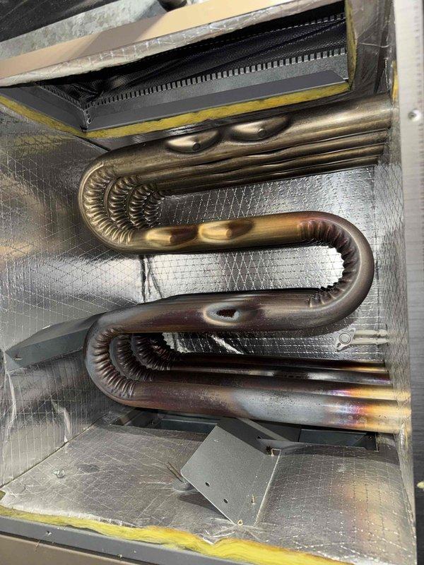 Performed routine maintenance tune-up on residential furnace system. Inspected heat exchanger and coils, noting normal copper oxidation on serpentine coils within acceptable parameters. Examined ductwork connections and verified proper insulation around unit; all components functioning correctly with no immediate service concerns identified.