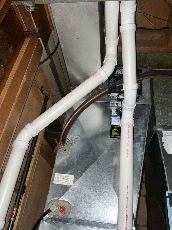 Performed comprehensive inspection of Carrier HVAC system located in utility area. Evaluation included examination of ductwork connections, with particular attention to the silver metallic flexible ducts and PVC pipe configuration. Recommended thorough cleaning of all accessible ductwork to improve system efficiency and indoor air quality.