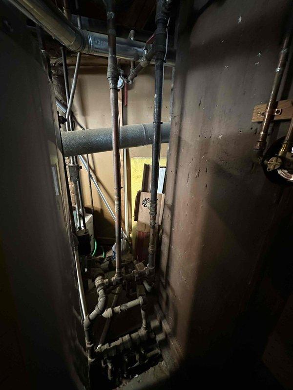 Conducted a comprehensive assessment of the existing utility area with focus on plumbing and mechanical systems. Documented the condition of copper piping, valves, and fittings in the wall cavity, noting signs of aging and discoloration. Evaluated the adjacent mechanical equipment for potential HVAC system replacement, with particular attention to integration with existing plumbing infrastructure.