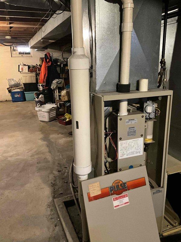 Performed inspection of existing Lennox Pulse furnace showing significant age deterioration and outdated technology. Documented current installation including PVC venting configuration and basement utility space constraints. Recommended complete system replacement with modern high-efficiency unit to address reliability concerns, improve energy efficiency, and ensure proper ventilation standards per current code requirements.