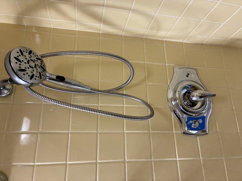 Performed comprehensive inspection of shower/tub fixtures, including examination of chrome showerhead with flexible metal hose and single-handle temperature control valve. Verified proper functionality of detachable showerhead mounting system and water flow regulation. No issues detected with tile installation or shower floor drainage.