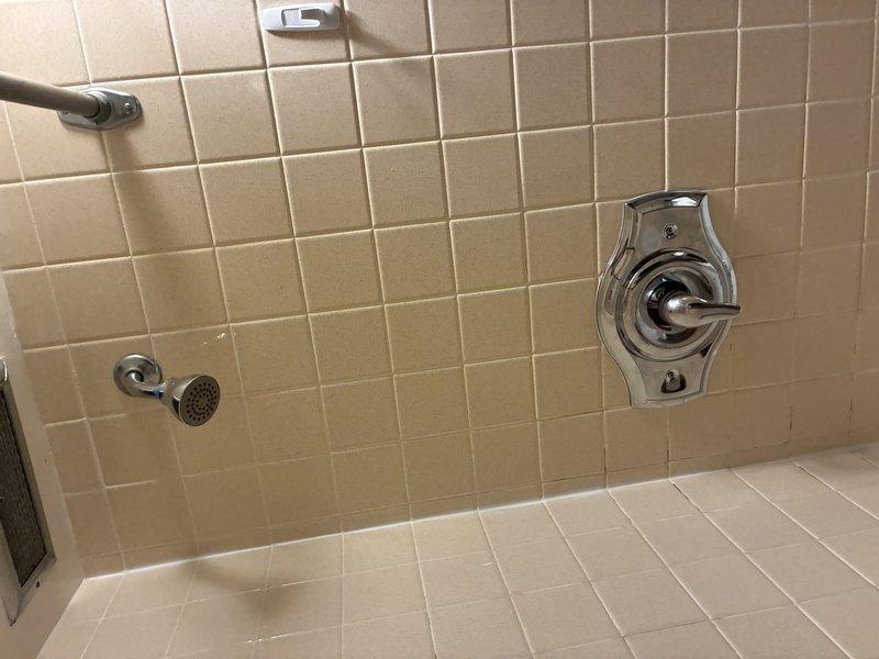 Performed comprehensive inspection of shower/tub fixtures, including examination of chrome showerhead with flexible metal hose and single-handle temperature control valve. Verified proper functionality of detachable showerhead mounting system and water flow regulation. No issues detected with tile installation or shower floor drainage.