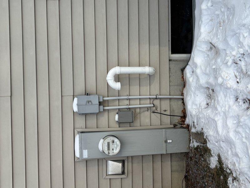 Completed installation of a new tankless water heater unit in utility area. Mounted unit on plywood backing board against wooden framed wall using proper metal brackets. Connected copper supply lines with appropriate shut-off valves and installed necessary electrical connections to exterior meter box. All systems tested and functioning properly.