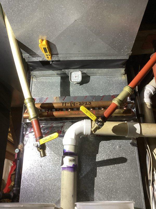 Performed comprehensive tune-up on HVAC system, inspecting gas valve assembly and associated control components. Verified proper operation of gas lines and electrical connections, noting all wiring (orange/yellow) was secure and intact. Examined plumbing connections including PVC and copper piping, checking multiple flow control valves for functionality. All components appeared properly installed with no signs of leakage or damage. System now operating at optimal efficiency.