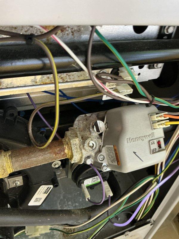 Performed comprehensive tune-up on Ducane HVAC system. Inspected Honeywell control valve and associated wiring connections (yellow, green, white, purple, blue). Noted mineral deposits and corrosion on brass/copper pipe joints requiring future attention. System operational but showing signs of age-related wear.